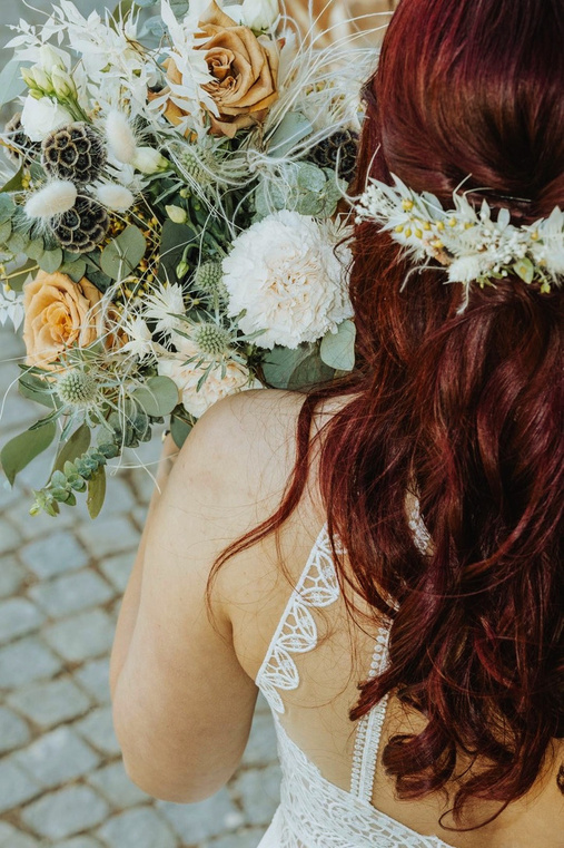 Braut mit Blumenschmuck im Haar, von hinten