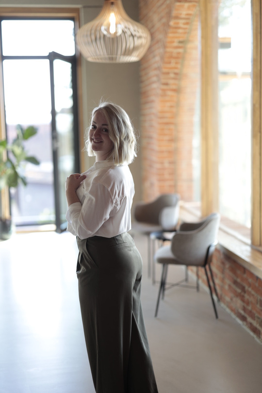 Frau in weißer Bluse in einem hellen Loft